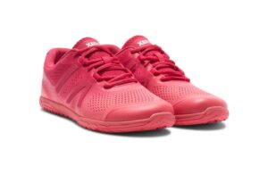 A pair of bright pink athletic shoes with a low-profile design offers comfort to digital nomads. Featuring a lace-up closure and perforated texture, these shoes boast a textured sole for superior grip and sport a logo on the tongue.