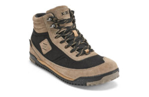 A high-top shoe featuring a beige suede upper with black mesh panels, designed for maximum comfort. It boasts black laces with beige accents and a rugged rubber sole, ideal for digital nomads on the go. The brand name is visible on the tongue, complemented by stitched details on the side.