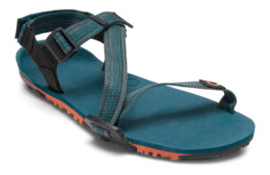 A teal and black sandal with adjustable straps and a thick sole promises comfort for digital nomads on the move. The sole's textured orange bottom ensures grip, while the toe loop and buckle closures offer a secure fit, perfect for casual or outdoor adventures.