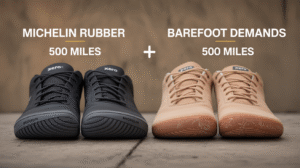 Two pairs of athletic shoes are displayed side by side on a concrete surface. The left pair features Michelin rubber soles for added durability, while the right tan pair from Xero Shoes is labeled "BAREFOOT DEMANDS 500 MILES.