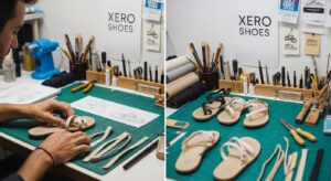 A workspace with design tools and sketches shows a maker assembling sandals. Several completed and partially assembled Xero Shoes are on a green cutting mat, reflecting the brand origins, with XERO SHOES signage in the background.