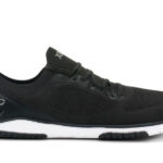 A black Xero Shoes Nexus Knit athletic shoe with a white sole, mesh upper, lace-up design, and "XERO" branding on the side and tongue, showcased in a sleek side profile—perfect for fans of minimalist footwear.