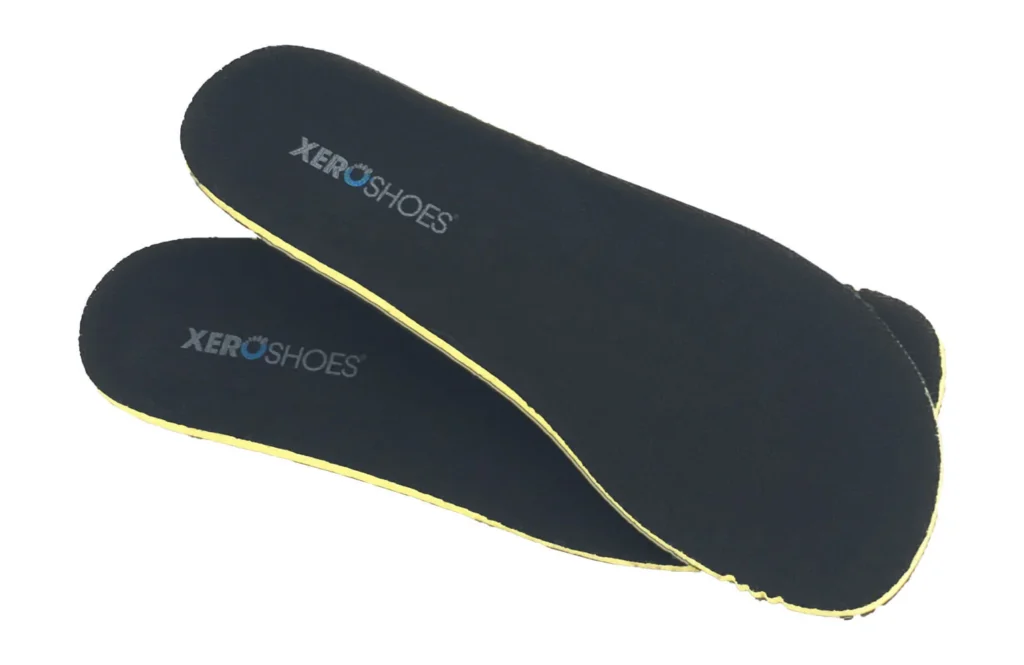 A pair of black Xero Shoes Insoles with yellow edges, branded in white and blue text, are displayed on a white background—designed for durability and comfort.