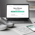 A pair of gray Xero Shoes, a laptop displaying the order status page to easily track your Xero Shoes order, a smartphone, a notepad with reminders, a coffee cup, and a potted plant sit neatly on a white desk.