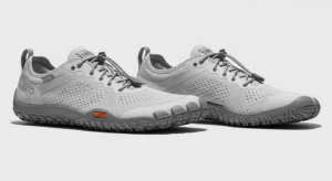 A pair of light gray barefoot-style athletic shoes from Xero Shoes, featuring textured soles, lace-up fronts, and a small orange "V-TRAIL" label on the side—showcasing quality craftsmanship on a plain white background.